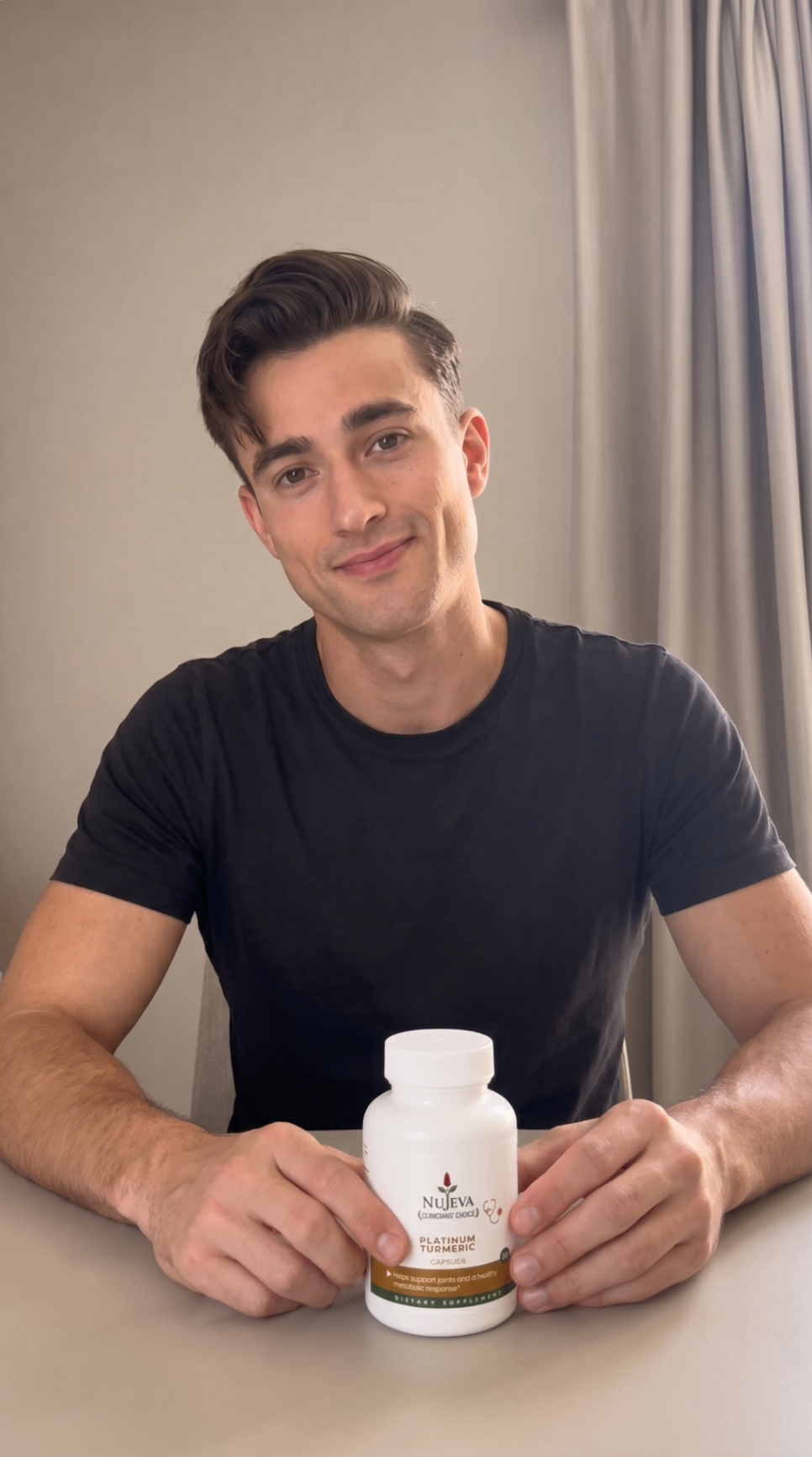Man at table holding Nūjeva Platinum Turmeric